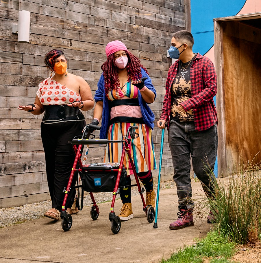 3 masked disabled people talking outside